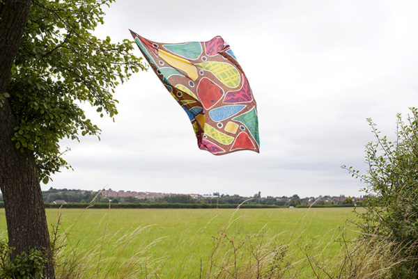A multicoloured silk scarf floats in the breeze