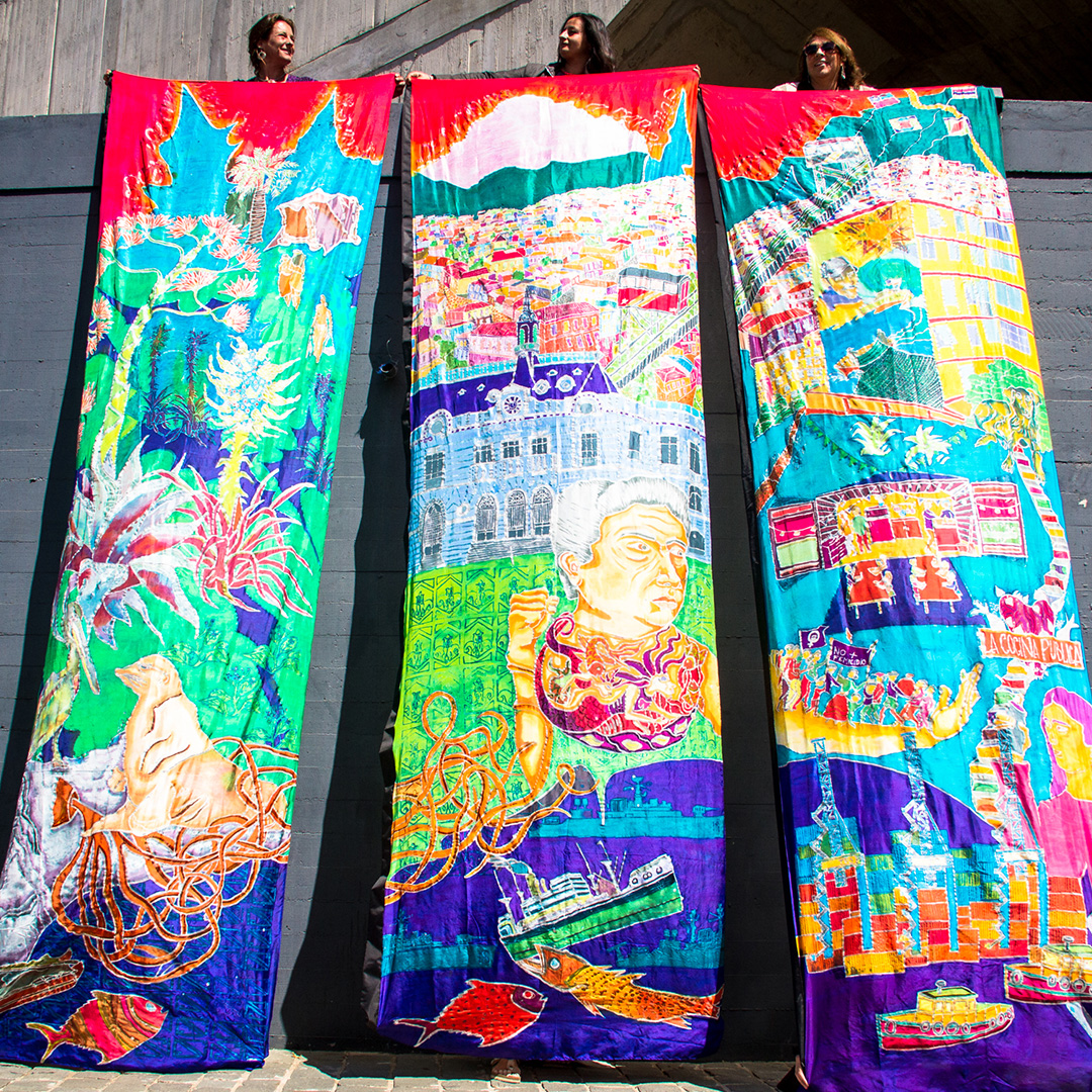 Three large silk banners with complex illustrations depicting features of the local area