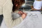 Artist applies wax to silk to create a pattern