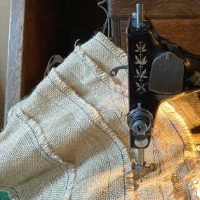 Vintage sewing machine sewing layers of hessian