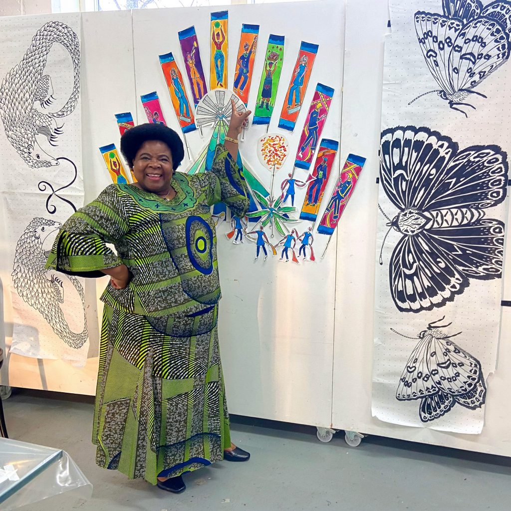 Valerie Muzelenga points at a drawing of the silk flag she will feature on