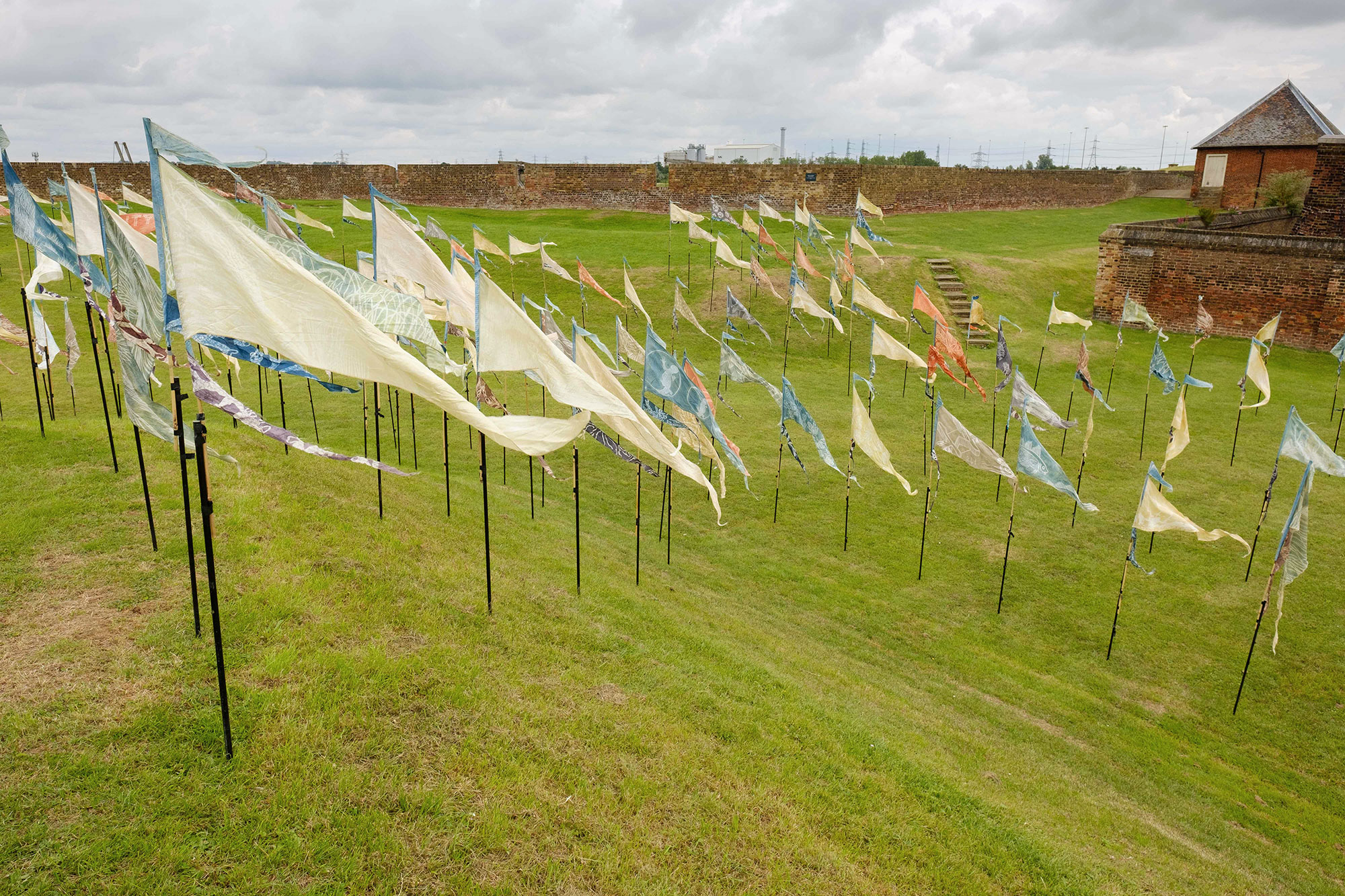 Hundreds of silk pennants decorate the grass interior of Tilbury Fort in the Beach of Dreams flag installation